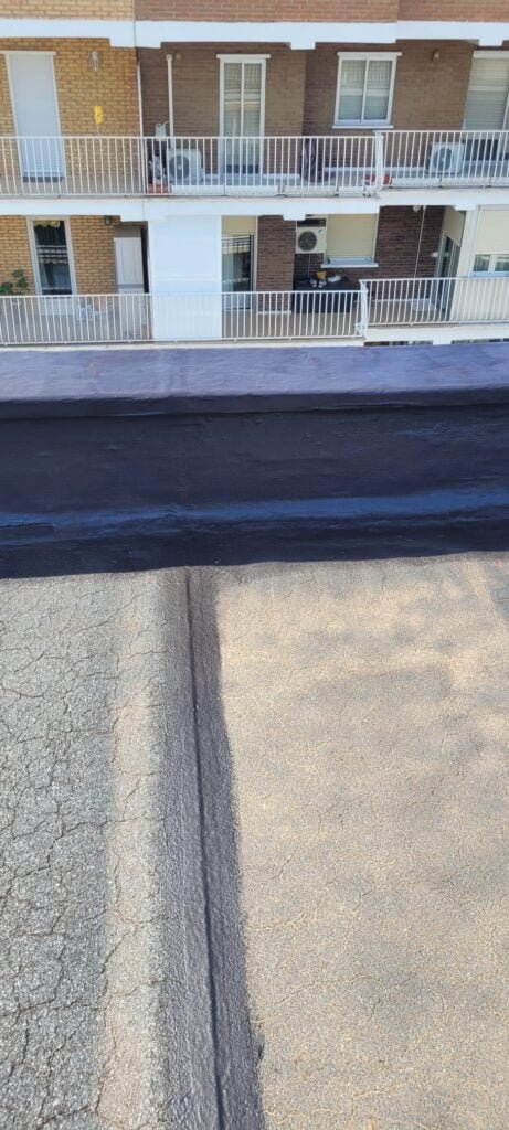 Aplicación de aislamiento térmico y acústico en un tejado plano, mejorando la eficiencia energética y reduciendo el ruido en el edificio